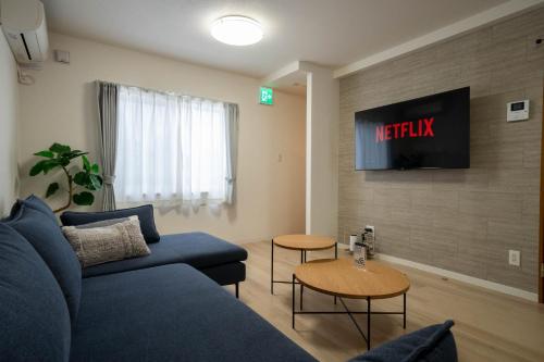 a living room with a blue couch and a tv at Flex cella satozuka - Vacation STAY 17763 in Sapporo