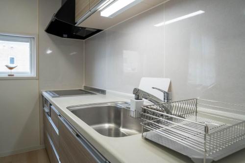 a kitchen with a sink and a dish drying rack at Flex cella satozuka - Vacation STAY 17763 in Sapporo