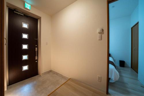 a room with a door and a room with a bed at Flex cella satozuka - Vacation STAY 17763 in Sapporo