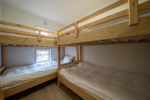 two bunk beds in a room with a window at Flex cella satozuka - Vacation STAY 17763 in Sapporo