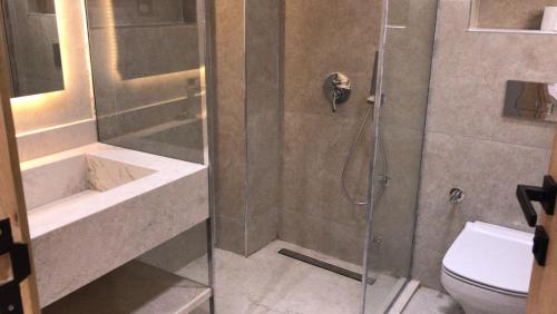 ein Badezimmer mit Dusche, Waschbecken und Toilette in der Unterkunft Magawish Hurghada Apartement 1 in Hurghada