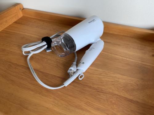 eine Nintendo-Wii-Fernbedienung auf einem Holzboden in der Unterkunft Ieka Village Kiyosasawa - Vacation STAY 71845v in Sadamitsu