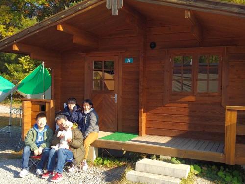 a group of people sitting in front of a tiny house at Minakami Outdoor Log & Auto Campsite - Vacation STAY 34003v in Obinata