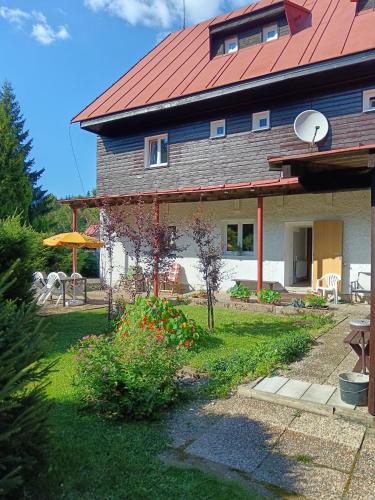 a house with a red roof and a yard at Horsky hotel Sport in Josefuv dul