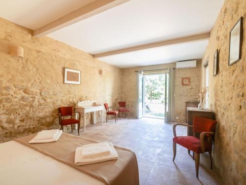 a room with a bed and a table and chairs at Domaine des Périès - Chambres d'hôtes in Saint-Martin-Lalande