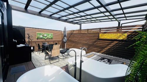 une salle de bains avec baignoire et une terrasse avec une table dans l'établissement BAYBERRY×airstream - Vacation STAY 34826v, à Izumi
