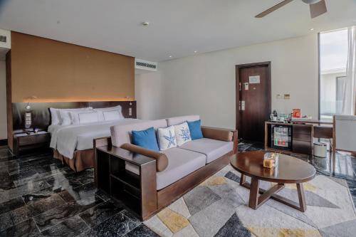 a bedroom with a bed and a couch and a table at Melia Danang Beach Resort in Da Nang