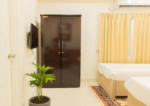 a room with a bed and a door with a plant at Hotel Granton in Hyderabad