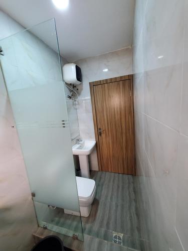 a bathroom with a toilet and a sink and a mirror at Romeo Suites & Apartment in Ipaja