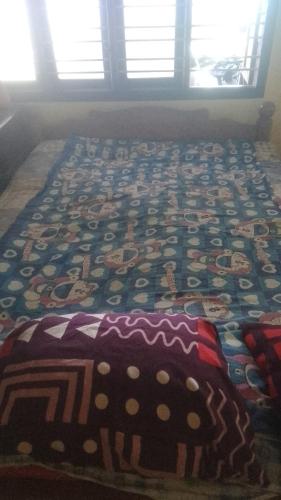 una cama con una colcha de colores encima en Krishna sadana beach side home stay, en Hangārkatta