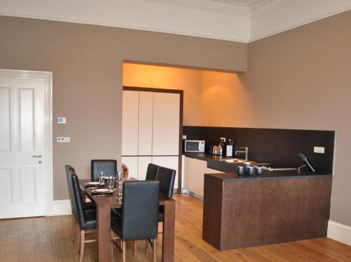 Un comedor con una mesa y sillas negras. en Dreamhouse Apartments Glasgow West End, en Glasgow