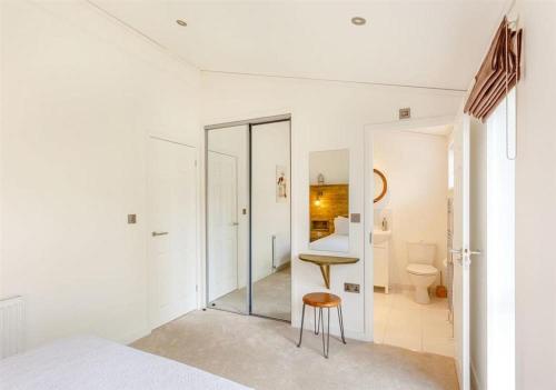 Sanctuary Caledonia Hot tub lodge في حصن أوغسطس: غرفة نوم بها سرير وكرسي وحمام