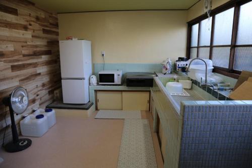 a small kitchen with a refrigerator and a sink at Nagomiso - Vacation STAY 42780v in Tsu