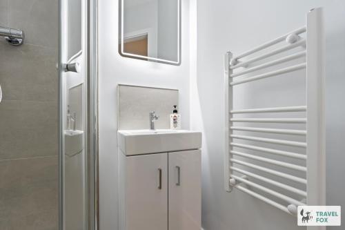 a white bathroom with a sink and a shower at Anna's Central Stay in Nottingham
