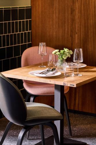 a wooden table with two chairs and wine glasses at Wroclaw Hotel in Wrocław