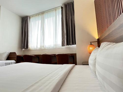 a hotel room with two beds and a window at Lantern Hotel in Ho Chi Minh City