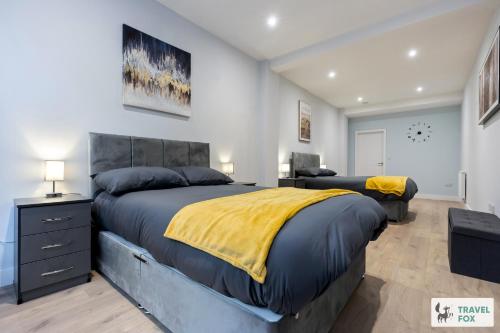 a bedroom with a large bed with a yellow blanket at Anna's Central Stay in Nottingham