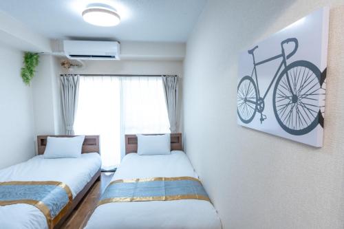two beds in a room with a bike on the wall at J,Fine Miyagino 101 - Vacation STAY 27982v in Gora
