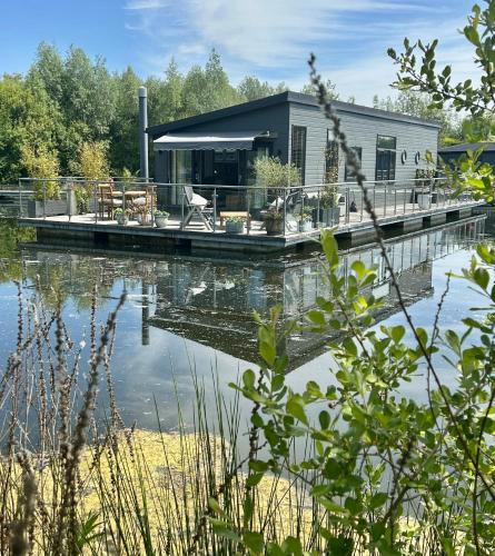 a house on a dock on a body of water at The Floating Home at Upton in Upton upon Severn