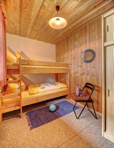 a bedroom with two bunk beds and a chair at Bayerwald-Ferienhof Schmid in Eppenschlag