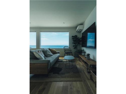 a living room with a couch and a view of the ocean at Viila NO°00 - Vacation STAY 34231v in Awaji
