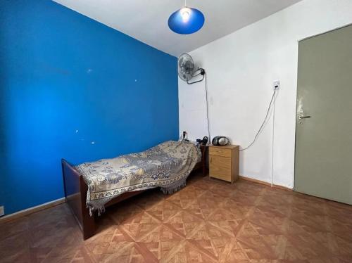 ein Zimmer mit einem Bett und einer blauen Wand in der Unterkunft Casalinda in Ciudadela