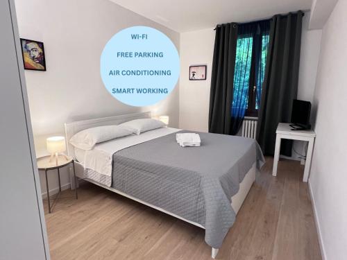 a bedroom with a bed and a sign that reads with free parking art conditioning smart at Lory Smart - Relax e Natura by RD Domus in Moncalieri