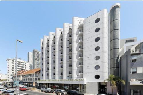 a large white building with black circles on it at Urban Elephant Express, The Flamingo in Cape Town
