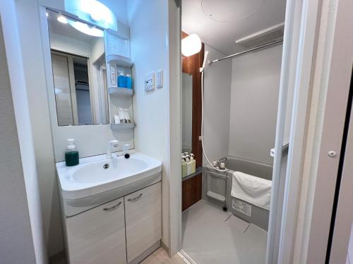 ein kleines Badezimmer mit Waschbecken und Spiegel in der Unterkunft Lion Heiwa Odori - Vacation STAY 18059 in Hiroshima