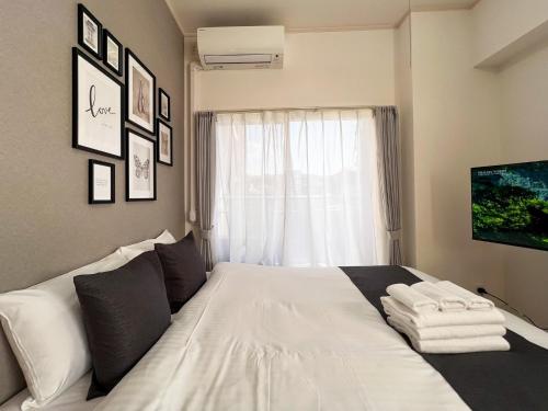 ein weißes Bett in einem Zimmer mit Fenster in der Unterkunft Lion Heiwa Odori - Vacation STAY 18060 in Hiroshima