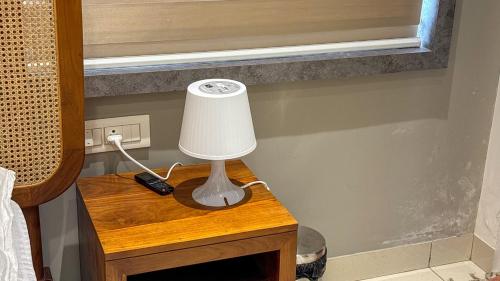 a lamp on a table next to a bed at Thulasi Avenue Inn in Pollāchi
