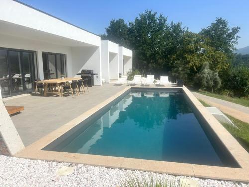 a swimming pool in front of a house at Casa Alto Horizonte in Estorãos