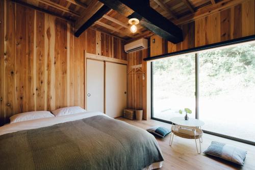 KasumigauraにあるGuesthouse Kominka Eguchiya - Vacation STAY 49007vのベッドと大きな窓のある寝室
