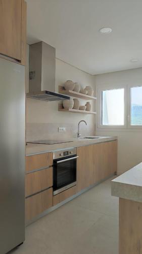 a kitchen with a sink and a refrigerator at Casa Alto Horizonte in Estorãos