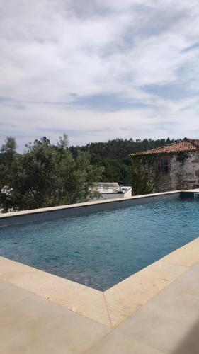 a swimming pool in front of a house at Casa Alto Horizonte in Estorãos