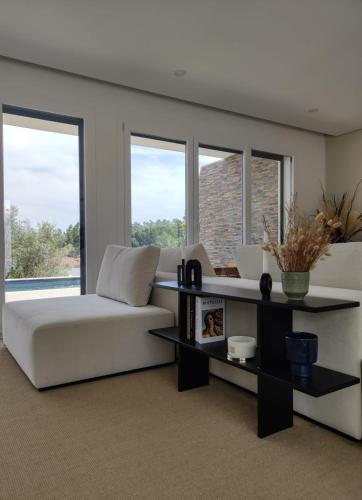 a living room with a white couch and windows at Casa Alto Horizonte in Estorãos