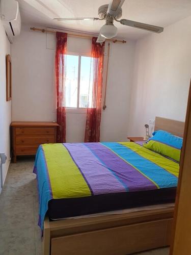 a bedroom with a colorful bed and a window at Casa Caprese in Vera