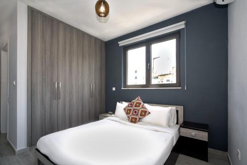 a bedroom with a white bed and a window at Luxury Modern Larnaca Central in Larnaka