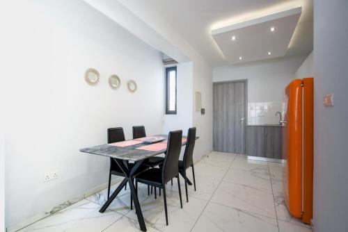a dining room with a table and black chairs at Luxury Modern Larnaca Central in Larnaka