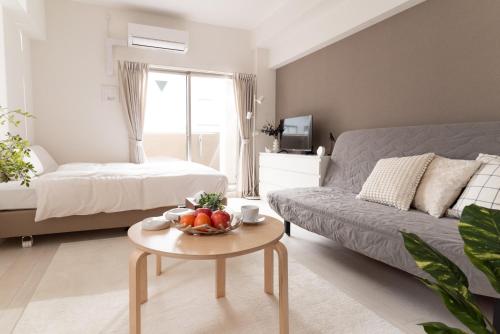 a living room with a couch and a table with fruit on it at WOM Condominium Tamatsukuri - Vacation STAY 64193v in Osaka