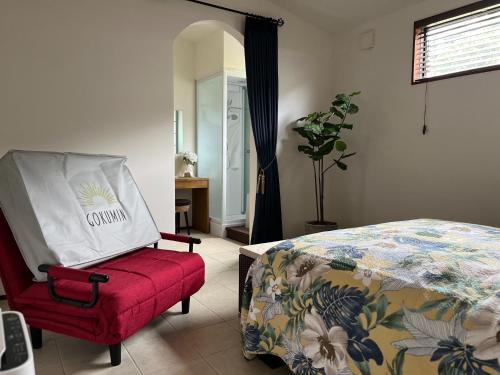 a bedroom with a bed and a red chair at Onomichi Villa Ayah - Vacation STAY 53453v in Onomichi