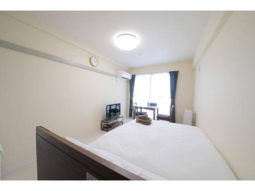 a bedroom with a large white bed in a room at City Avenue Asahimachi - Vacation STAY 18053 in Sapporo