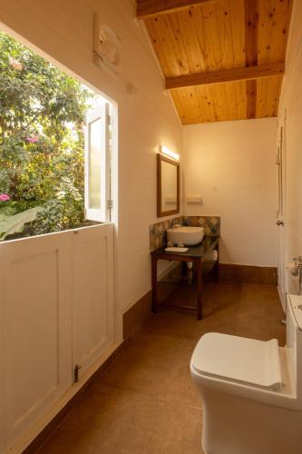 a bathroom with a toilet and a window at Zen By The Sea in Betalbatim