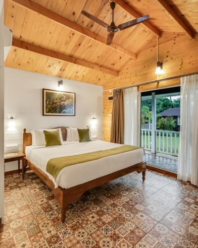 a bedroom with a large bed and a balcony at Zen By The Sea in Betalbatim