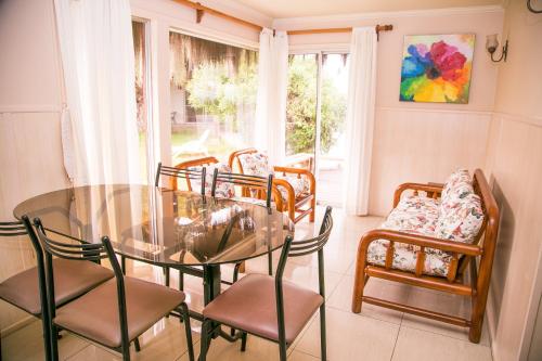 a dining room with a glass table and chairs at Cabañas Las Añañucas I in La Serena