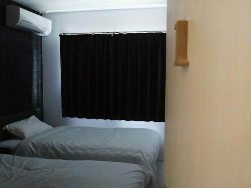 a bedroom with two beds and a window with a black curtain at Building A - Vacation STAY 72722v in Kikuchi