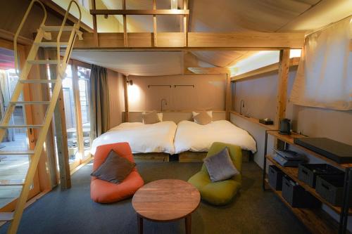 a bedroom with a bunk bed and two chairs at THE BASE GLAMPING YUGAWARA Kanagawa Glamping - Vacation STAY 74518v in Miyakami
