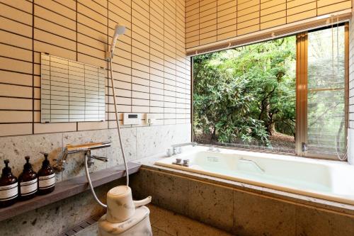 a bathroom with a bath tub and a window at Soubokuan - Vacation STAY 77265v in Sengokuhara