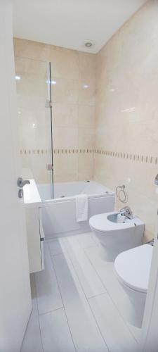 a bathroom with two sinks and a tub and a toilet at Casa do Mar - Luxurious Villa with Swim Spa & sea view in Luz