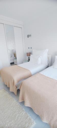two beds sitting next to each other in a bedroom at Casa do Mar - Luxurious Villa with Swim Spa & sea view in Luz